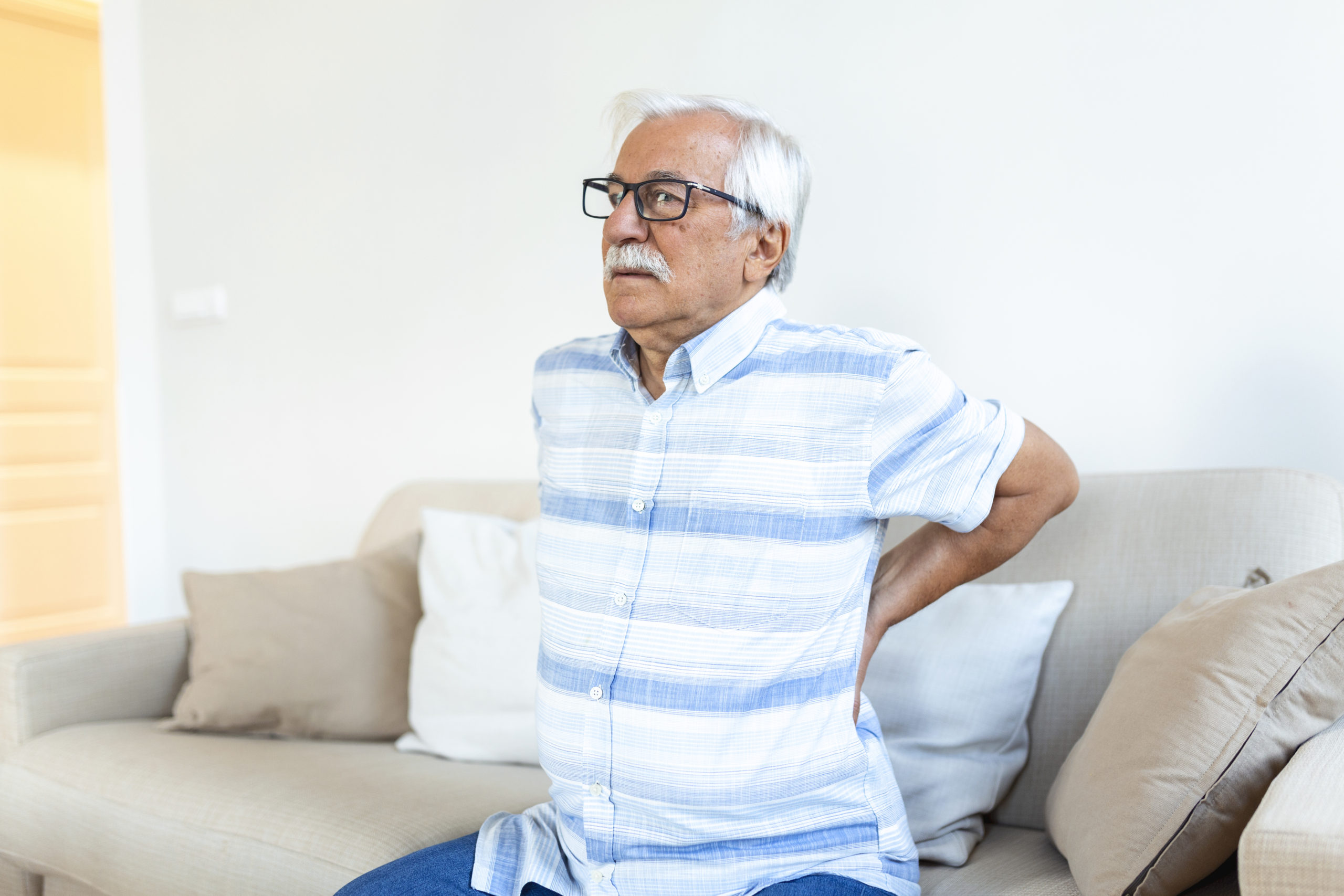 Senior man suffering from pain in back. Elderly man having discus hernia